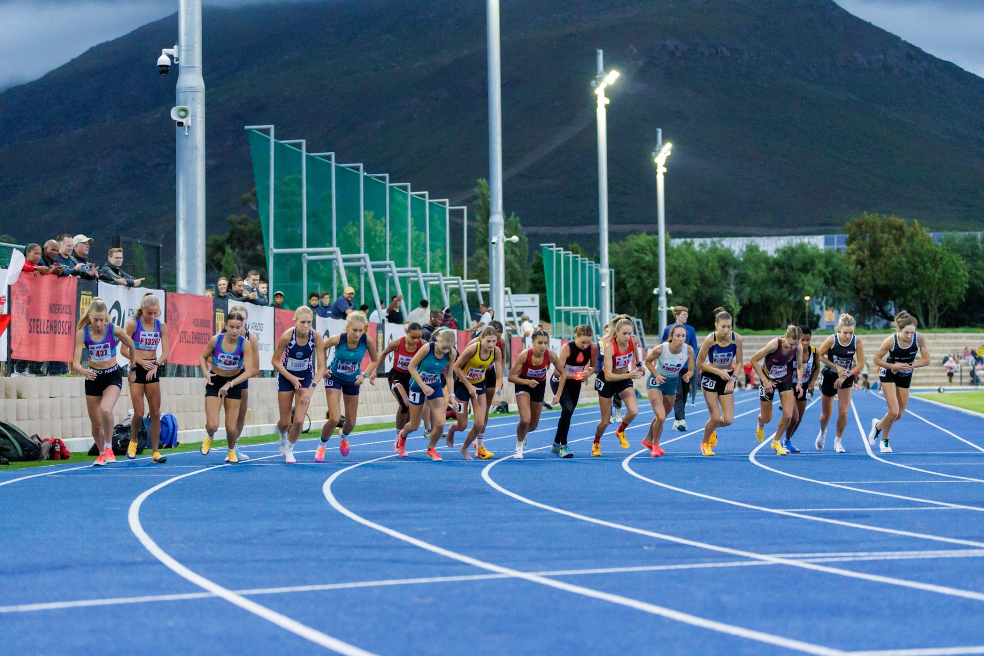 Sprinters poised at the start line of an athletics track