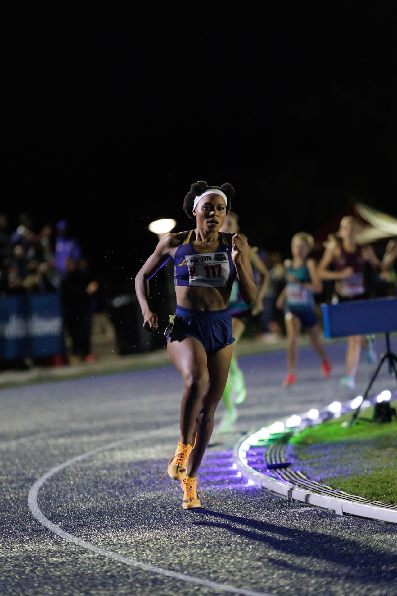 Athletes racing under stadium floodlights